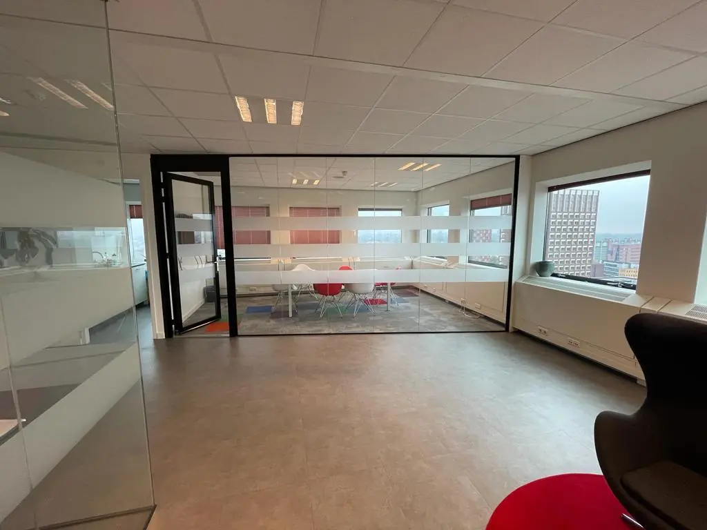 Moderne vergaderruimte met glazen wanden op een hoger gelegen verdieping aan het Johanna Westerdijkplein.